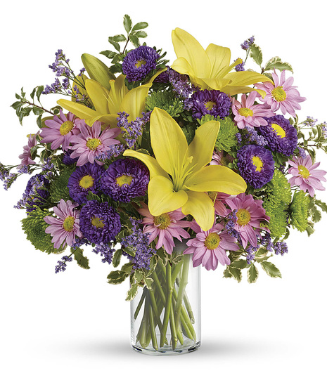 Roses, lilies, and more purple and green flowers in a classic cylinder vase