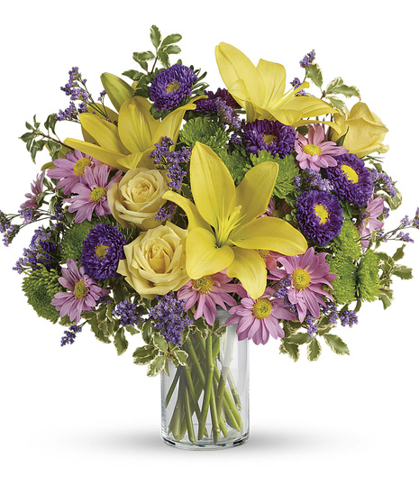 Roses, lilies, and more purple and green flowers in a classic cylinder vase