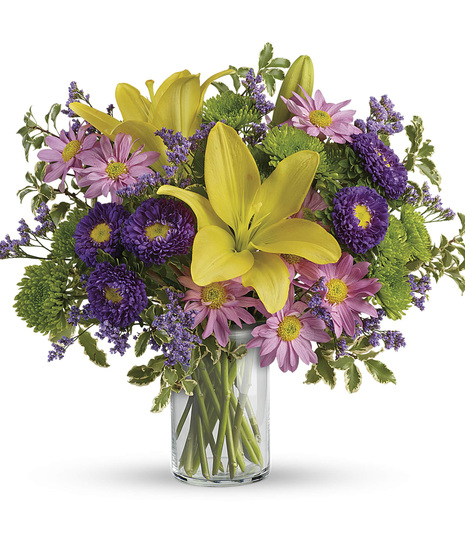 Roses, lilies, and more purple and green flowers in a classic cylinder vase