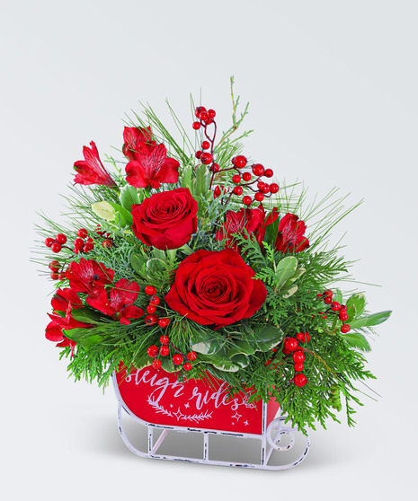 This vibrant arrangement includes Roses, Carnations, Alstroemeria, and is accented with premium foliage designed in a vintage style metal sleigh