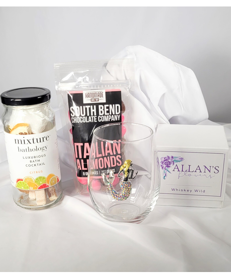 Gift basket with a stemless wineglass, candle, chocolate covered almonds, and a Mixology bath cocktail kit