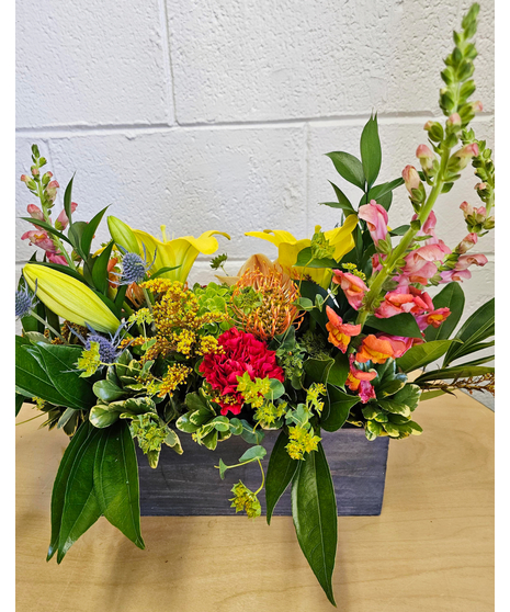 Thanksgiving centerpiece in a wooden box with lilies, protea, snapdragons, hydrangea and fall accents