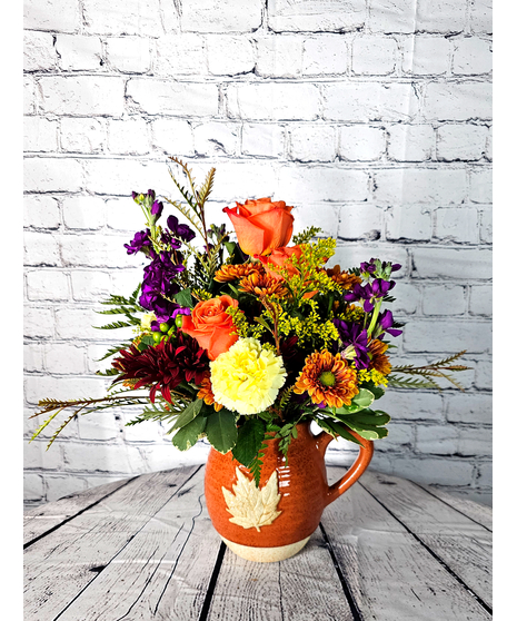 Pitcher features premium roses, chrysanthemums, carnations and stock