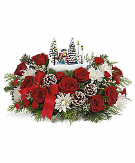 Featuring red roses, miniature red carnations, white mums. Accented with winter greens, delivered in our Thomas Kinkade's Holiday Skate Party Keepsake