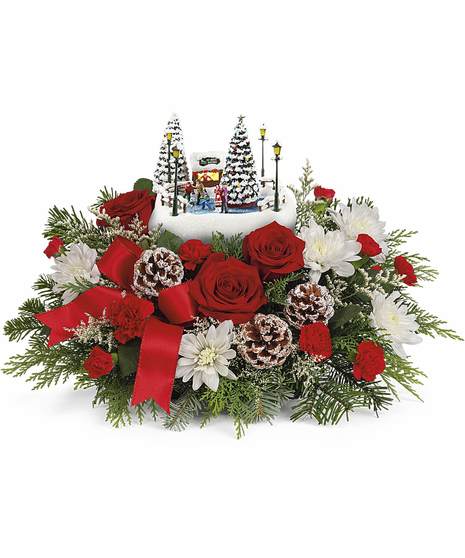 Featuring red roses, miniature red carnations, white mums. Accented with winter greens, delivered in our Thomas Kinkade's Holiday Skate Party Keepsake